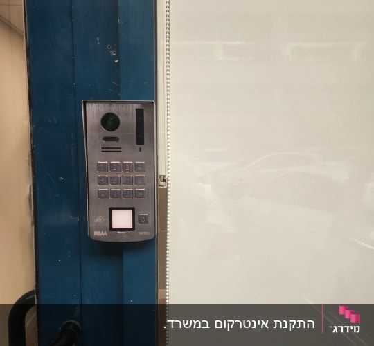 אינטרקום עם מצלמה ולוח מקשים על דלת